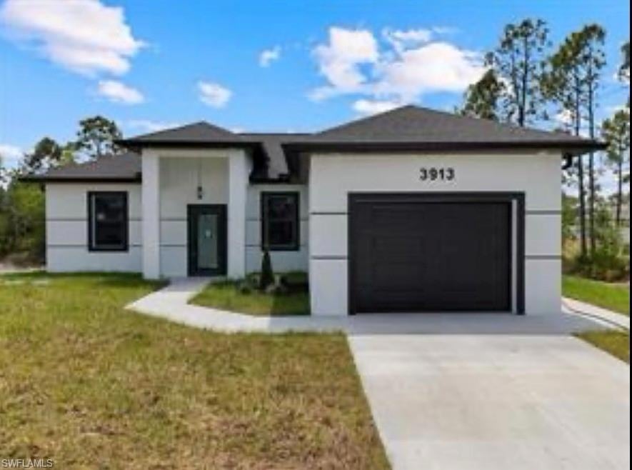 View of front facade featuring driveway, an attached garage, a front yard, and stucco siding