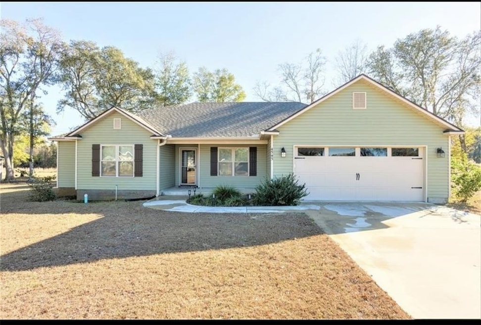 Ranch-style house with covered porch, concrete driveway, roof with shingles, and an attached garage