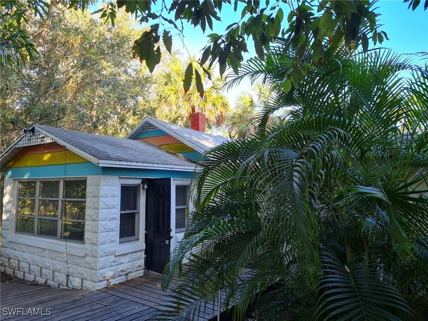 View of side of home featuring stone siding, roof
