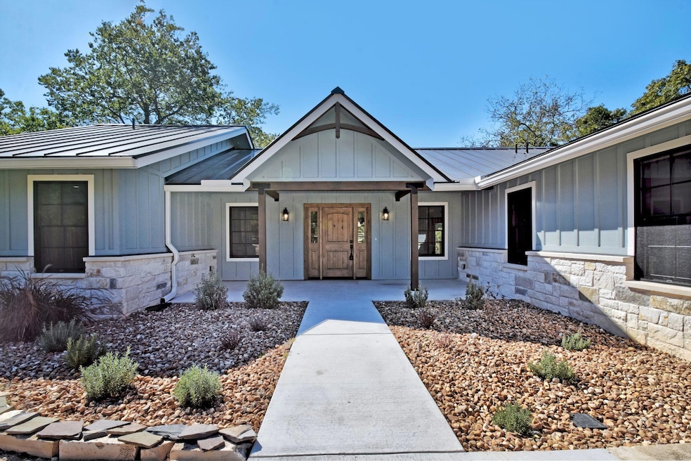 Property entrance with a standing seam roof, board and batten siding, stone siding, and a metal roof
