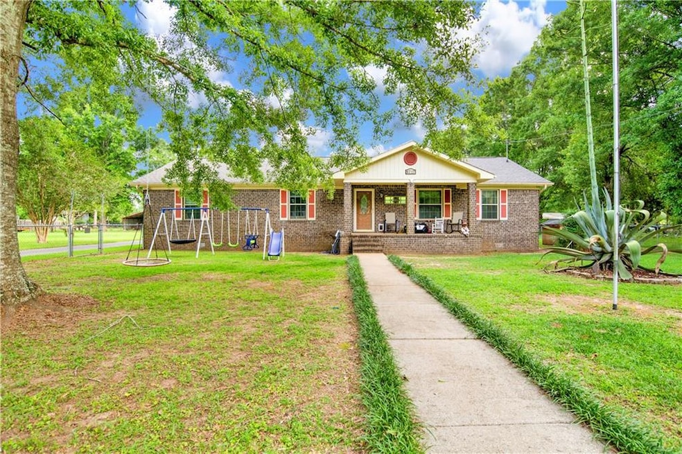 View of front of property with a playground, brick siding, and a porch