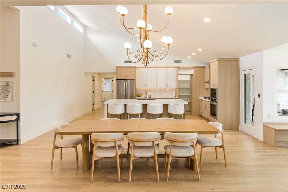 Dining room with a chandelier, high vaulted ceilin