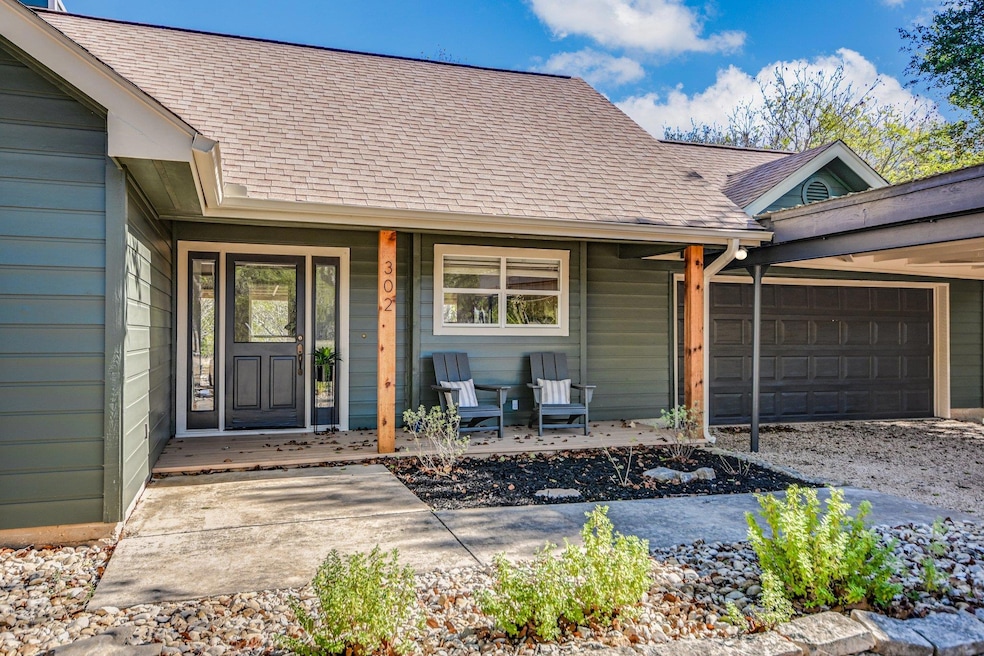 Property entrance featuring roof with shingles, covered porch, and an attached garage
