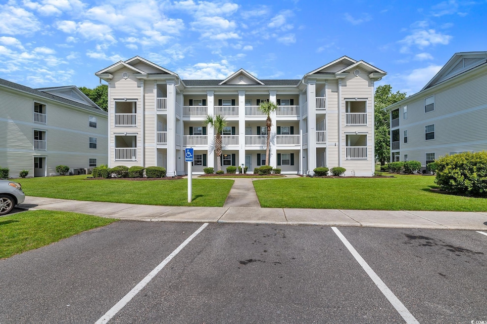 View of building exterior featuring uncovered parking