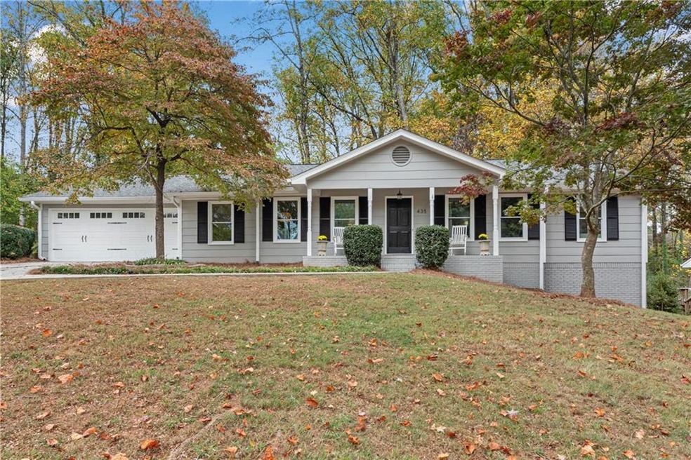 Ranch-style home featuring a garage, a front yard,
