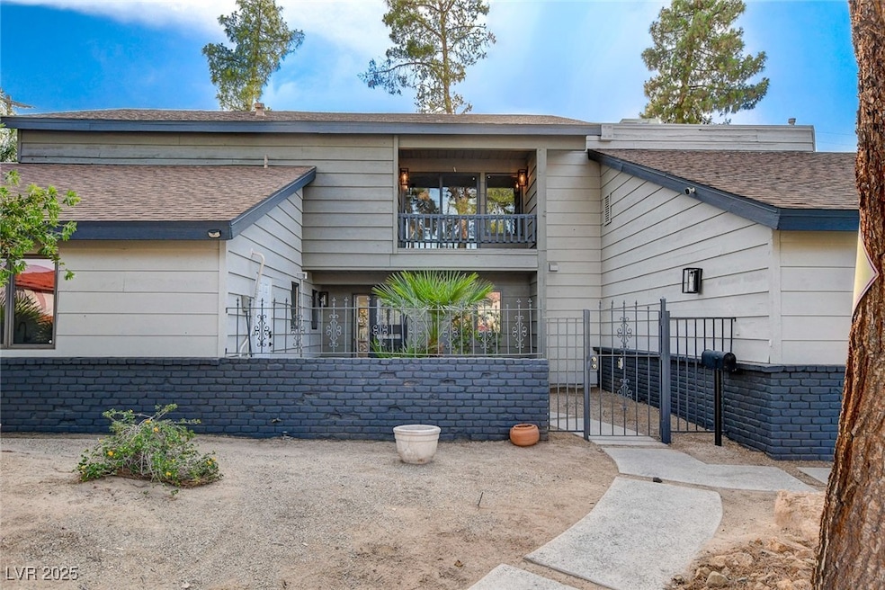 View of front of home featuring a balcony, a gate,