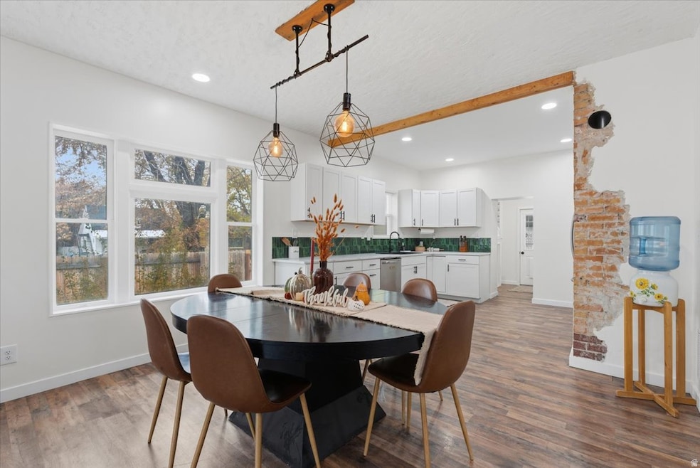 Dining room with light wood-style flooring and recessed lighting