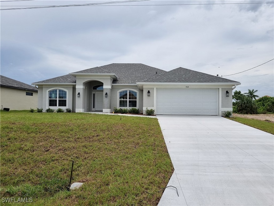 Ranch-style home with a garage and a front lawn