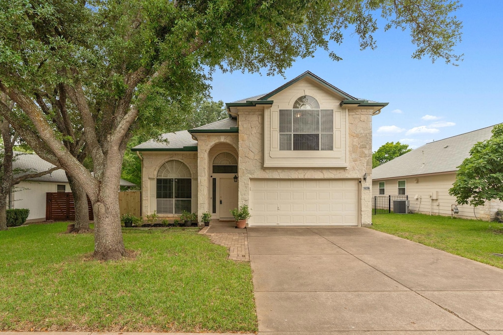 Traditional home with stone siding, a garage, cen