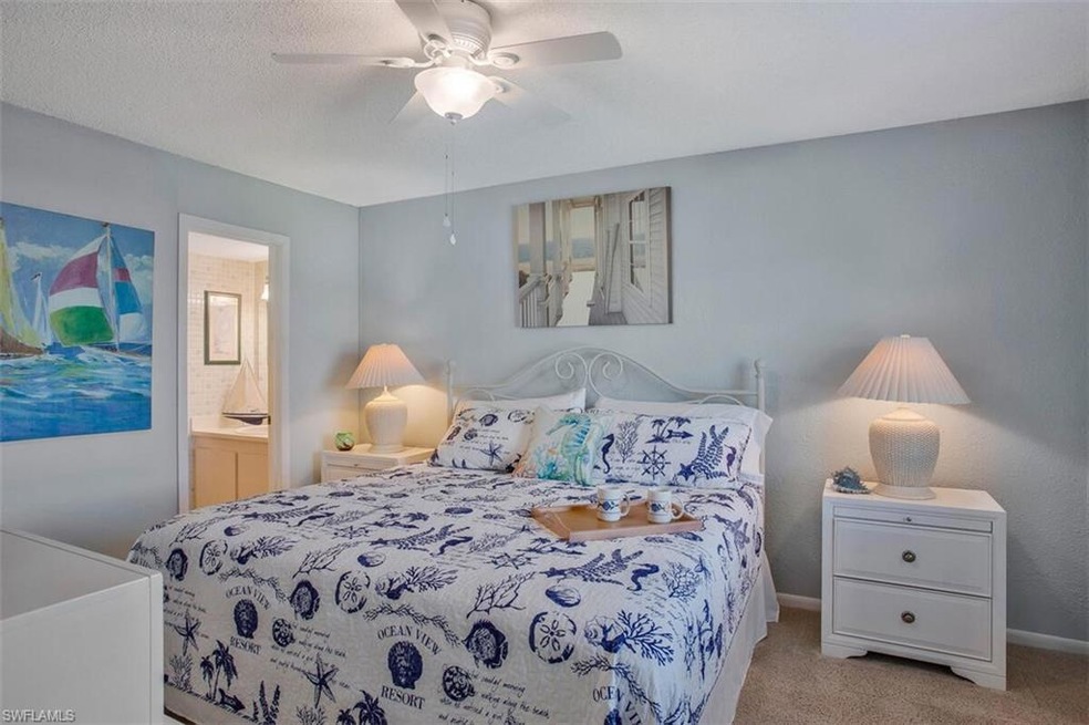Carpeted bedroom with ceiling fan, a textured ceil