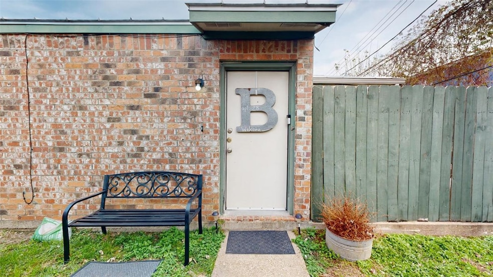 View of exterior entry with brick siding and fence
