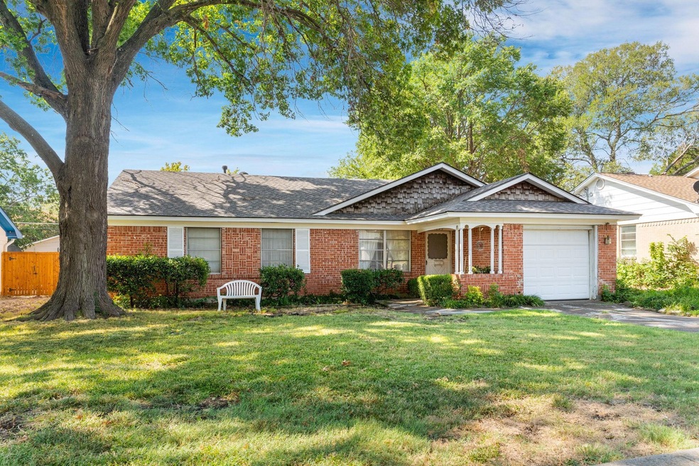 Ranch-style home featuring a garage and a front ya