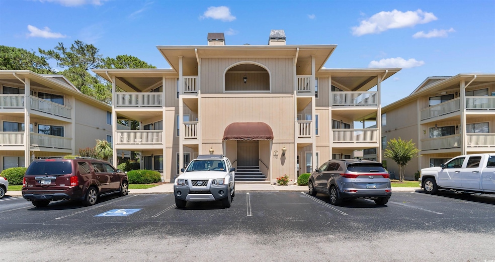 View of apartment building / complex with uncovered parking