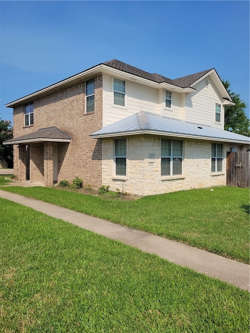 View of side of property with a yard, stone siding