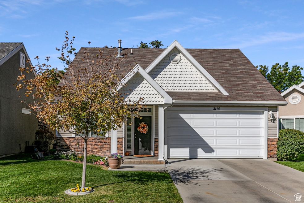 View of front of house with driveway, a front lawn, an attached garage, and a shingled roof