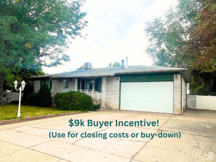 Single story home featuring an attached garage, brick siding, and driveway
