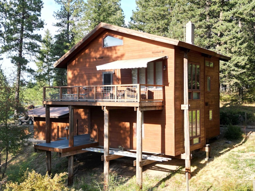 Back of house featuring a chimney and a wooden deck