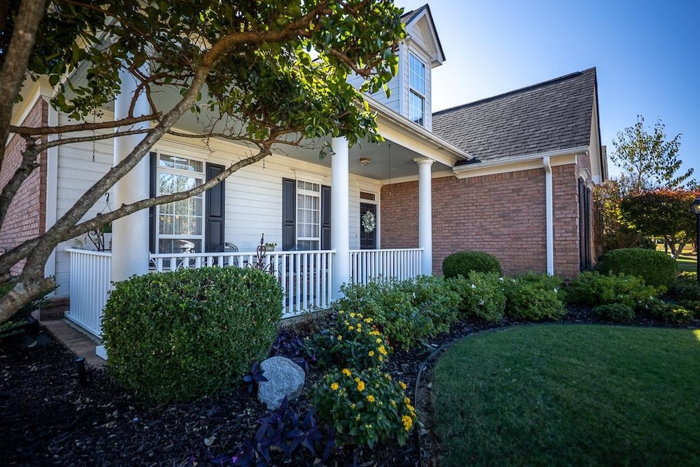 View of front of property with covered porch, roof with shingles, brick siding, and a front lawn