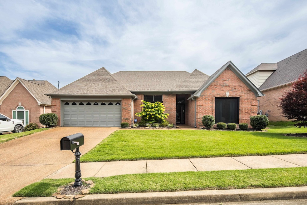 View of front of house featuring brick siding, a garage, concrete driveway, and a front lawn