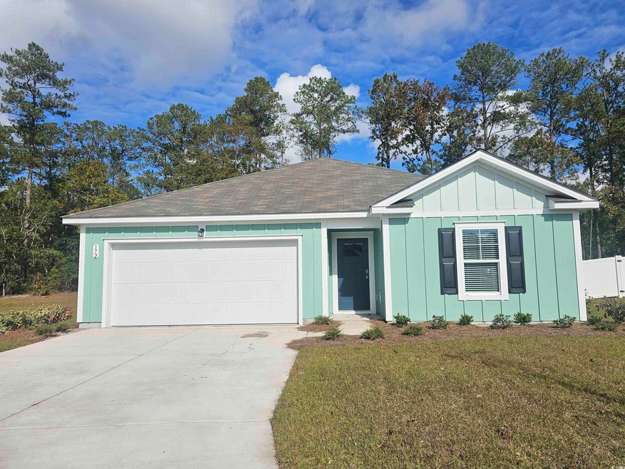 Ranch-style home featuring a front yard and a gara