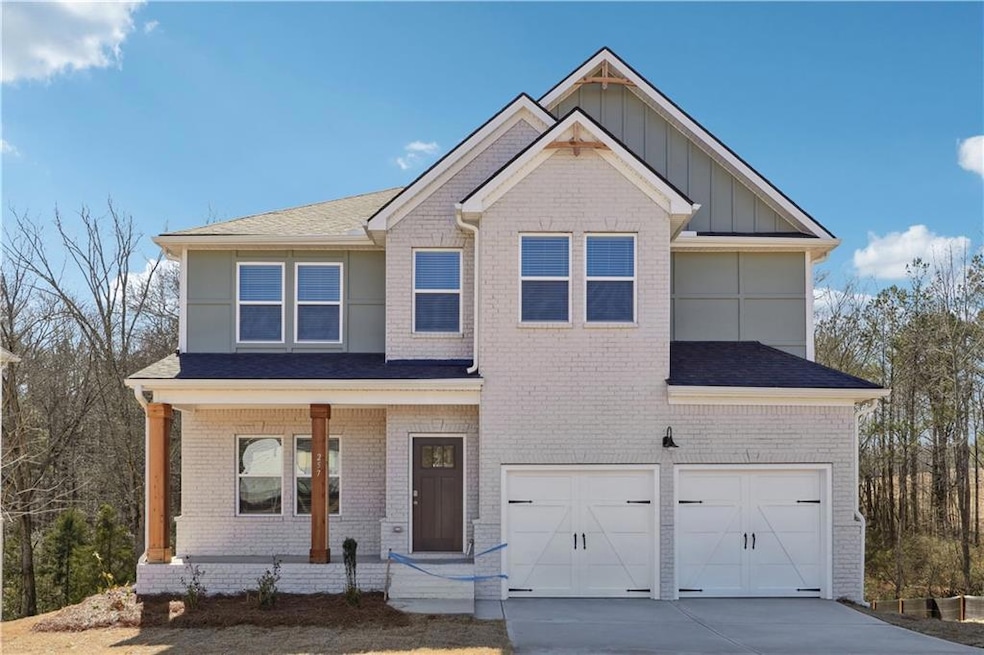 View of front facade featuring a porch, a garage, 