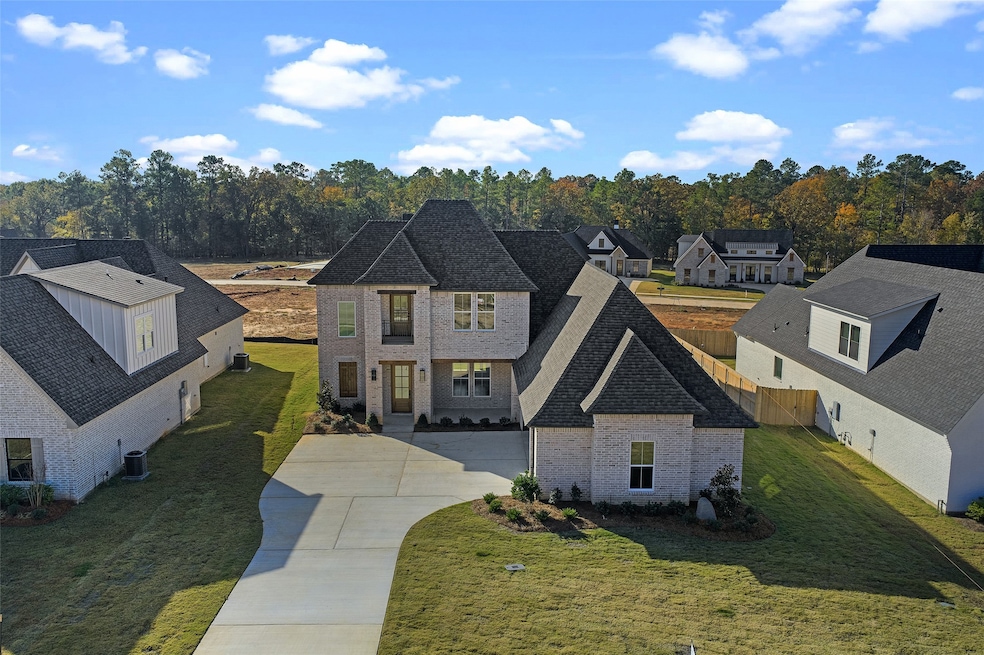 View of front of house featuring brick siding, concrete driveway, and a shingled roof