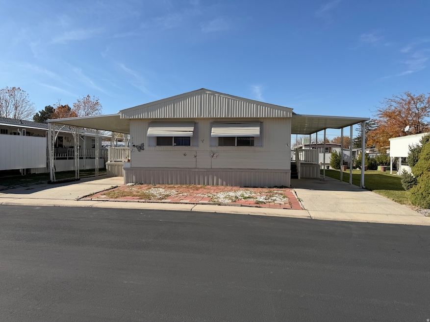 View of front facade with a carport and concrete driveway