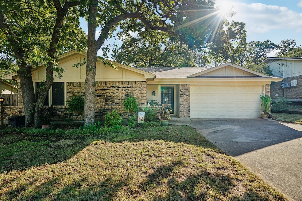 View of front of home with brick siding, concrete driveway, a garage, and a front lawn