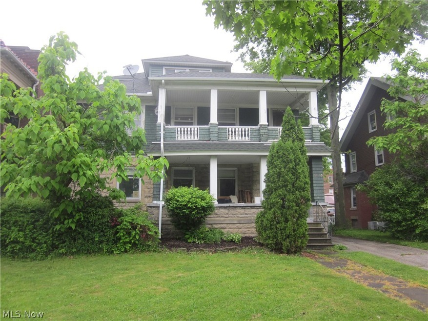 View of front of property featuring a front yard and a balcony