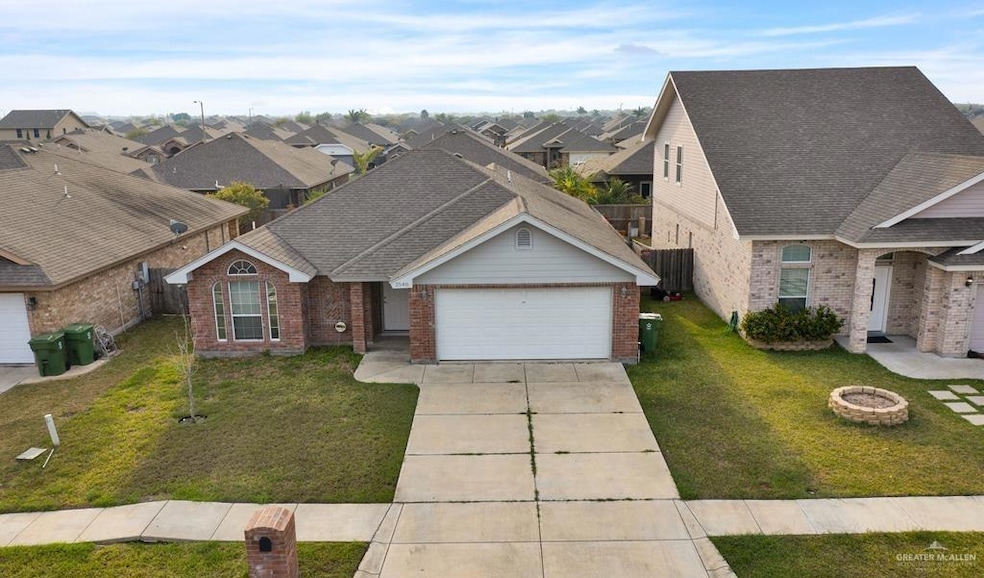 View of front of property featuring a front yard and a garage