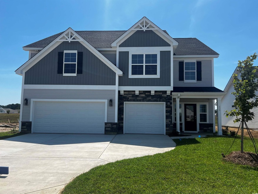 Craftsman house with a garage and a front lawn
