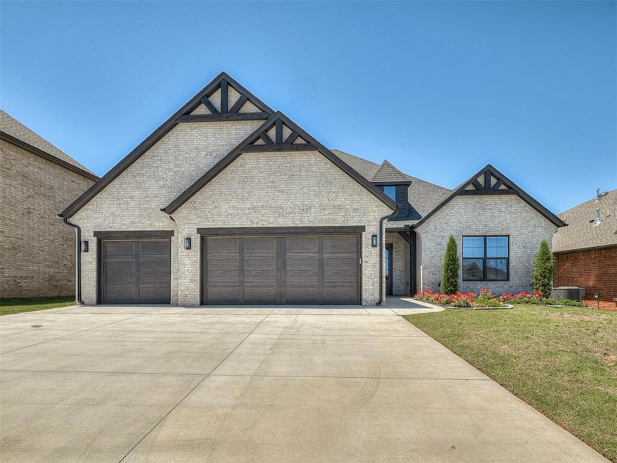 French country style house featuring driveway, brick siding, a garage, and a front lawn