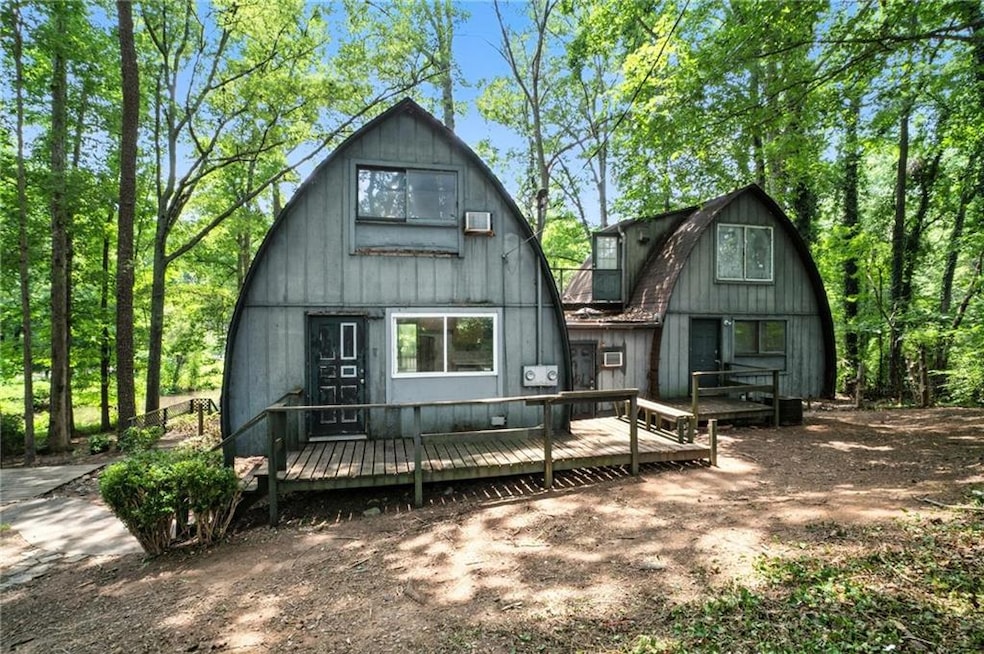 Rear view of house featuring a gambrel roof and a wooden deck