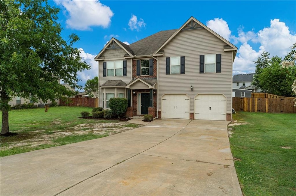 View of front of property with a garage, driveway, and brick siding