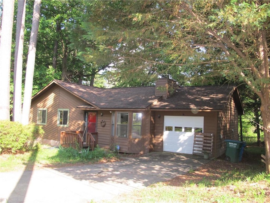 View of front of house featuring asphalt driveway,