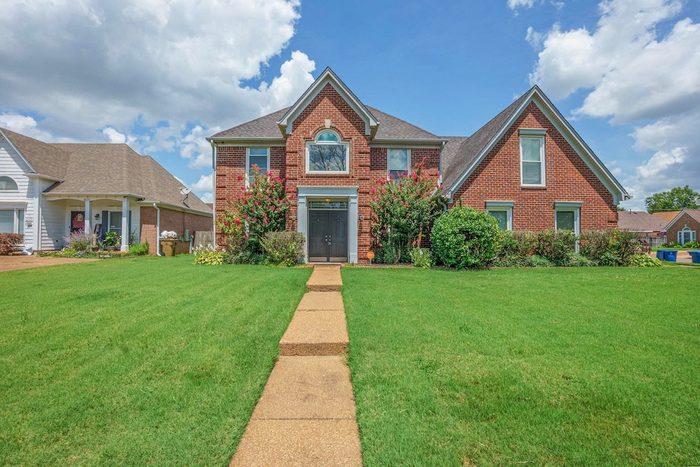 View of front of house featuring a front lawn, brick siding, and a shingled roof