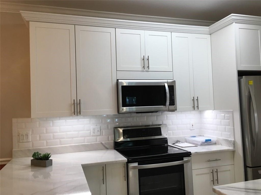 Handsome kitchen features custom cabinetry, subway