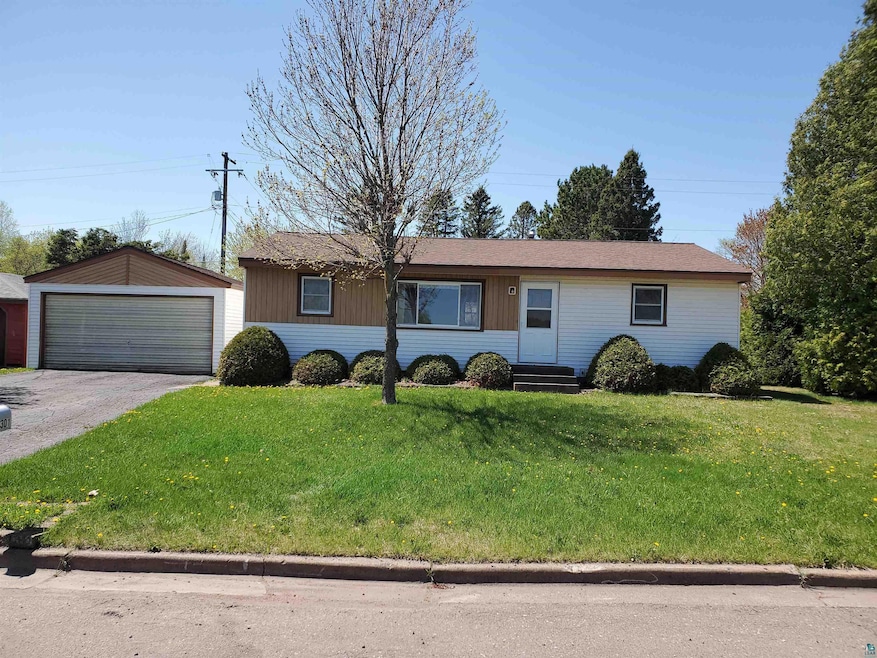 Ranch-style house with a garage, a front lawn, and