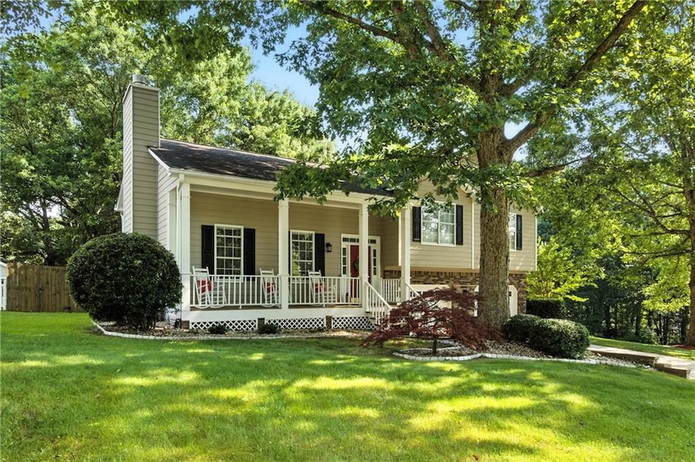 View of front of home featuring a porch, a chimney, and a front yard