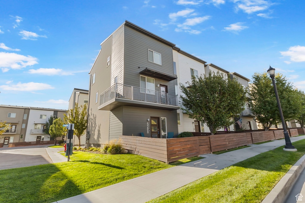 View of front facade with a balcony and a front lawn