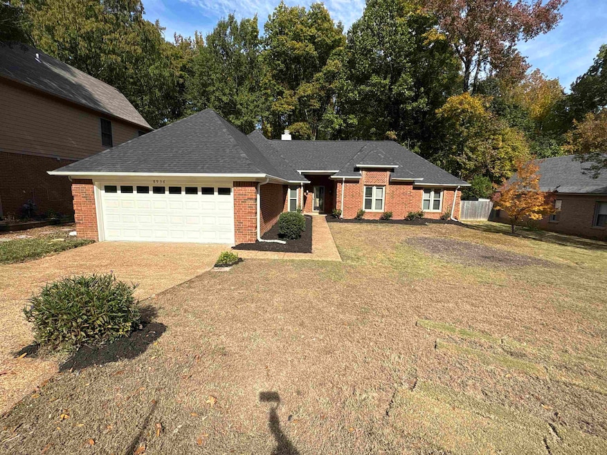 Ranch-style house with driveway, roof with shingles, a garage, brick siding, and a front yard
