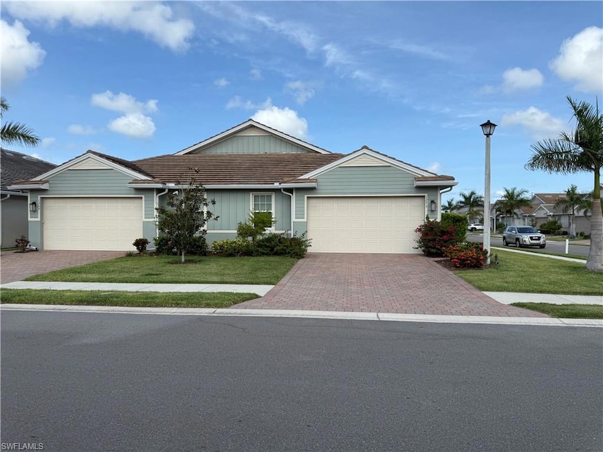 Single story home featuring a garage, decorative driveway, and a front lawn
