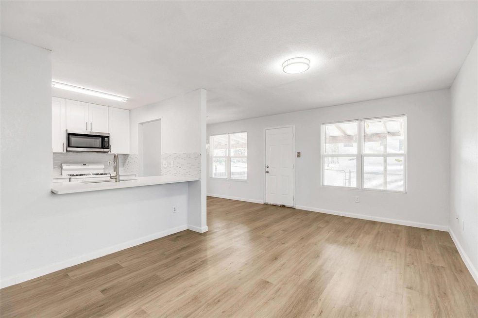 Kitchen with stainless steel microwave, white ran