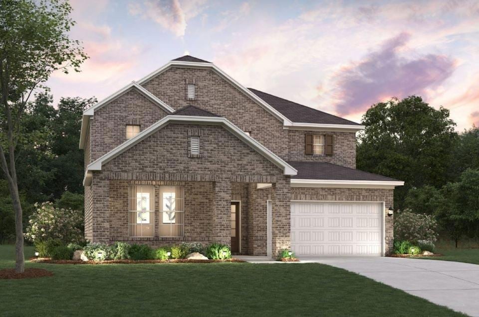 View of front of home with concrete driveway, brick siding, and a front lawn