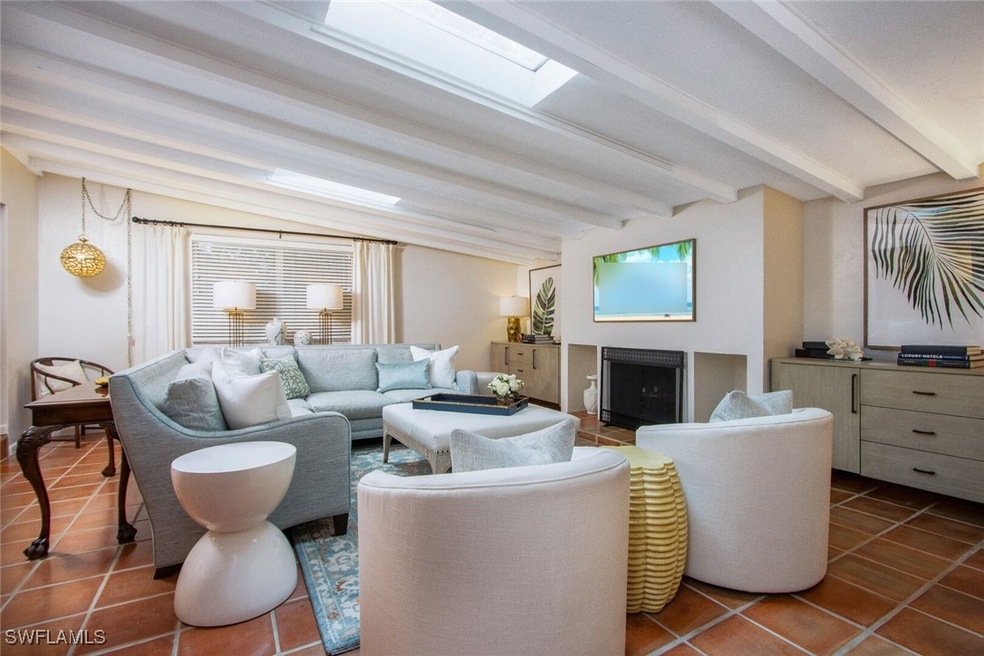 Living room featuring beam ceiling and dark tile p