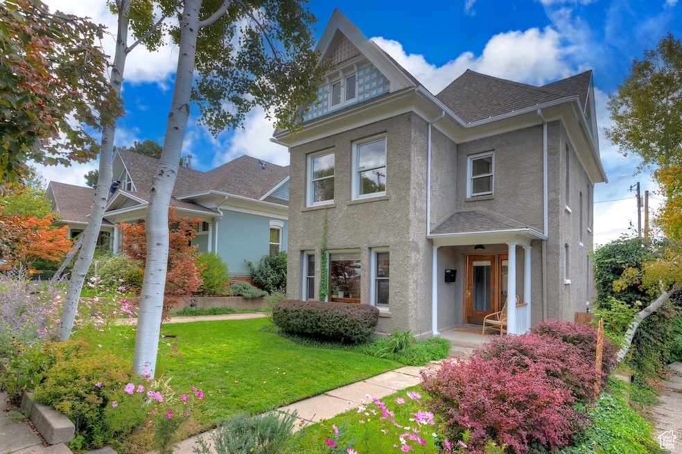 View of front of property with a front lawn, stucco siding, and roof with shingles