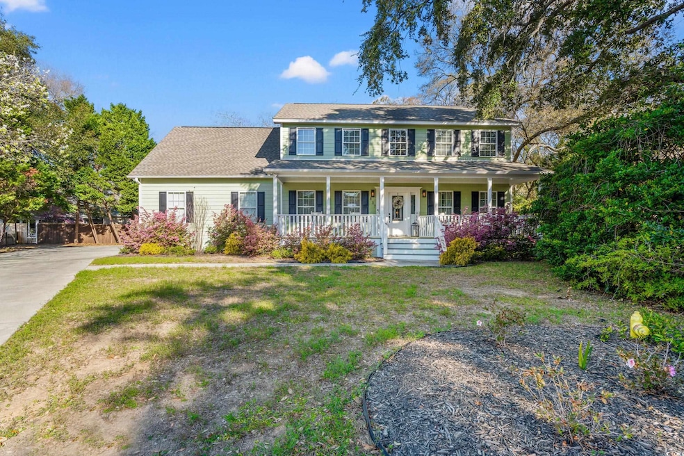 Colonial-style house with a front yard and a porch