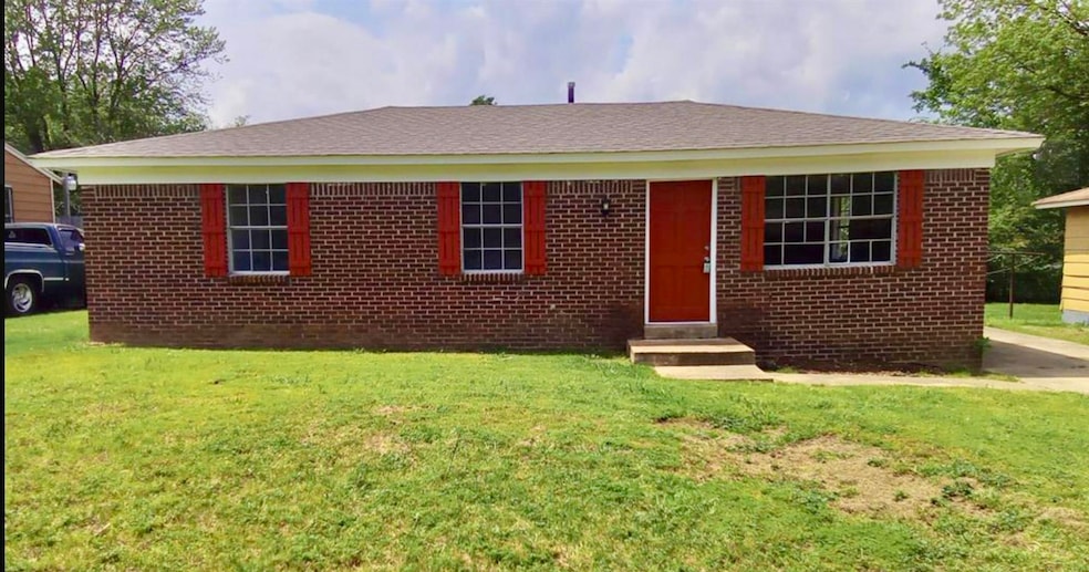 View of front of house with a front yard, brick siding, and entry steps