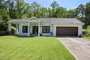 View of front facade featuring a front lawn and a garage