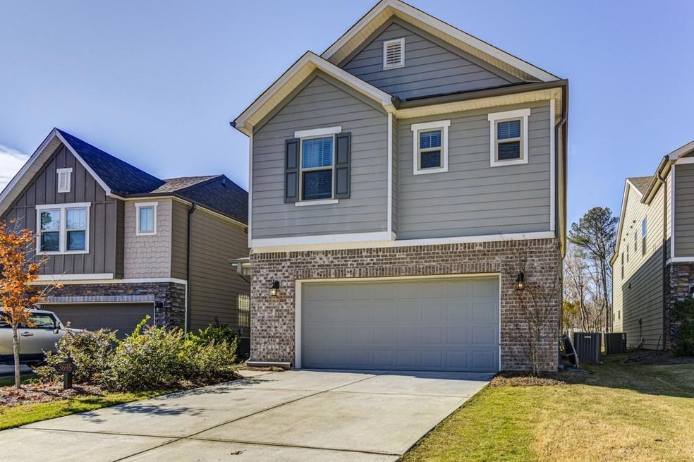 View of front facade with cooling unit, a garage, 